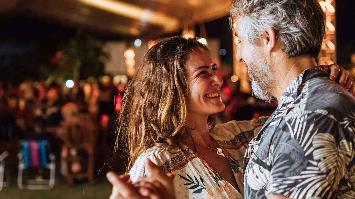 Casal dançando forró sorrindo durante o festival